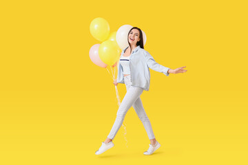 Poster - Beautiful young woman with balloons on color background