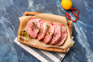 Board with fresh raw meat and spices on color background