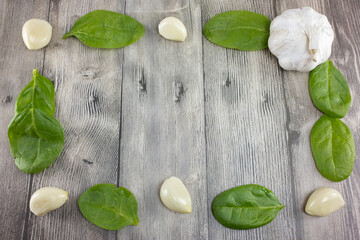 Background image with heads of natural peeled garlic and lettuce leaves