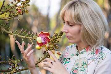 Portrait of a young blonde girl with exotic flowers of Asian cannonball tree