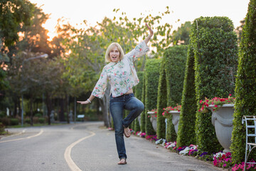 Wall Mural - Blonde European girl spends her holiday actively in the Asian park, walking and having fun.