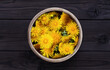 Dandelion in a wooden bowl on a dark wooden background. Fresh dandelion flowers picked in the garden for tea or making essences. For cooking, medical and cosmetology