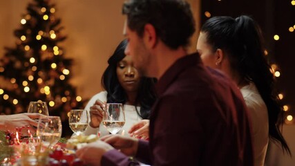 Canvas Print - winter holidays, celebration and people concept - happy friends having christmas dinner at home and drinking wine