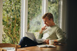 © Jacob Lund - Man at home looking at laptop and thinking
