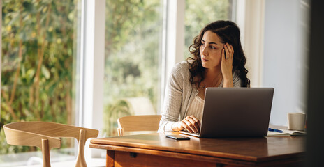 Thoughtful woman working at home