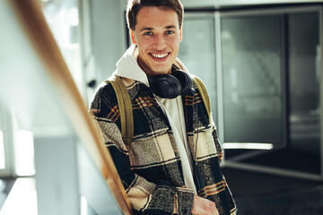 Wall Mural - Young man smiling at camera at college staircase