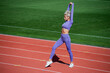© be free - full of energy. athletic lady warming up on stadium running track. female athlete do sport workout. trainer or coach training. perfect body shape. healthy and sporty. sexy fitness woman in sportswear