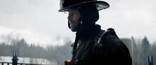 Hero Shot Portrait Of American Male Firefighter In Full Gear Standing In The Smoke. Shot With 2x Anamorphic Lens 