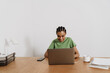 © Drobot Dean - Black smiling woman working with laptop while sitting at table