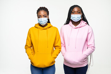 Happy two young african woman in medical mask isolated on white background