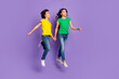 © deagreez - Full length photo of joyful young two children good mood jump up isolated on violet color background