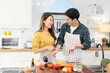© sirikorn - Portrait young couple in love helping to cook In a romantic atmosphere at home with smile face.