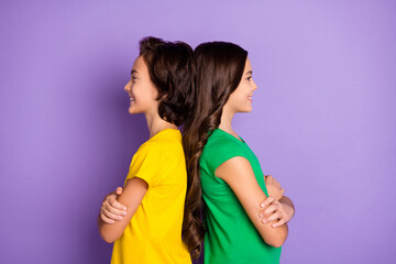 Sticker - Profile side photo of young cheerful kids back-to-back happy smile folded hands look empty space isolated over violet color background