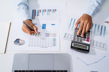 Wall Mural - Woman accountant use calculator and computer with holding pen on desk in office. finance and accounting concept