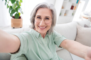 Sticker - Portrait of cheerful woman sit on sofa make selfie toothy smile enjoy spend free time vacation home indoors