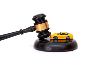 Yellow car on wooden judge gavel isolated on white, concept picture about car credit debt or divorce.