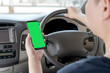 © photobuay - Mock up of man using mobile smart phone inside a car. Driver hand holding blank green screen smartphone, searching address and pin location via map navigator application, transportation