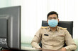 © ULTRAPOK - A Thai government officer, Civil servant Wearing a medical mask and sitting in the office.