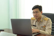 © ULTRAPOK - A Thai government officer, Civil servant using a laptop.