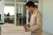 © ULTRAPOK - A Professional level Thai government officer, Civil servant using photocopiers at work.