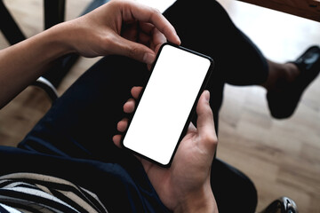 Top view male hand holding smartphone with blank screen at coffee shop
