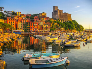 Lerici , Italy- June 5, 2010: Boats of Lerici docked in Lerici port and famous Italian Gulf of Poets. San Giorgio castle on the background at sunset. La Spezia province, Ligurian Coast of Italy.