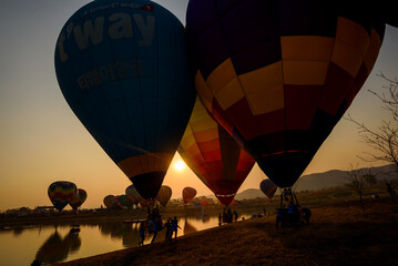 Silhouette hot air balloon over mountains lake in sunset sky