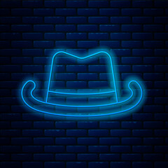 Wall Mural - Glowing neon line Western cowboy hat icon isolated on brick wall background. Vector