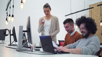 Young developer sharing new ideas about project to his partners in office working room. Multiethnic coworkers discussing over new business project in modern loft interior.