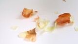 Fototapeta Tulipany - Peels of yellow onion falling down the table during cooking, peeling onion for making homemede food