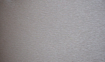 Rough-finished surface of dark gray metal with characteristic sanding marks.