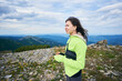 © anatoliy_gleb - Woman is holding smartphone, mountains on background.