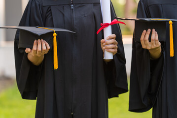 Wall Mural - Female graduates of a university graduate holding a degree certification to shows and celebrate education. success on the college.