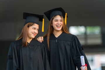 Wall Mural - Female graduates of a university graduate holding a degree certification to shows and celebrate education. success on the college.