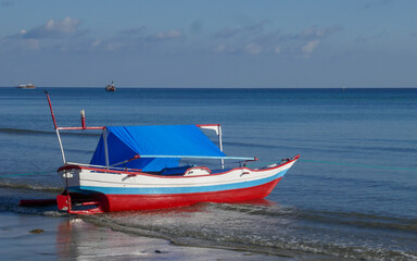 Poster - Minimalist view of small colorful wooden fishing boat with calm sea and horizon in Tanah Beru, Bulukumba, South Sulawesi, Indonesia