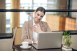 © zinkevych - Young businesswoman in beige jacket working in the office and looking positive