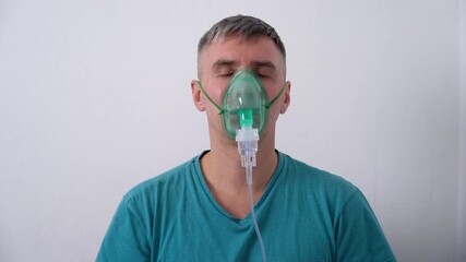 male struggling to breath as he wears an oxygen mask and self isolates from covid-19 pandemic.