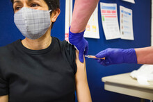 Asian Woman Getting Covid 19 Vaccine Injection, UK