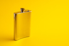 Stainless Metal Alcohol Bottle On Yellow Background. Hip Flask Alcohol Container. Flask Isolated