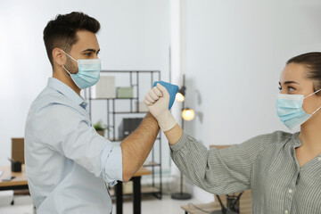 Wall Mural - People greeting each other by bumping fists instead of handshake in office