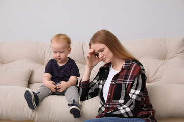 Depressed single mother with child in living room