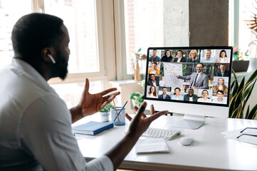 Sticker - African American successful man, ceo, manager, consultant, holding an online business conference, with multiracial employees, sitting at their desk at home, gesturing hands, discuss about strategy