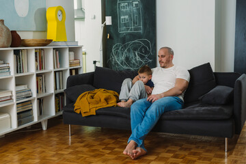 Canvas Print - father and sitting sofa in living room at home