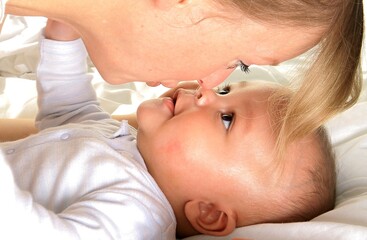 Wall Mural - baby in mother's arms and been cared for after having a good sleep in bed stock photo