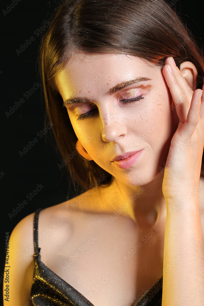Beautiful woman with unusual makeup on dark background