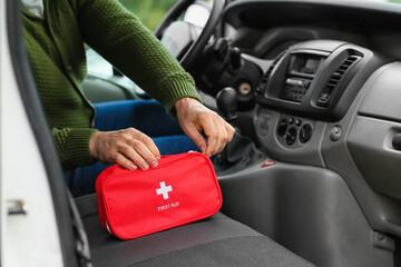 Man with first aid kit in car