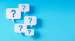 © peterschreiber.media - Question mark speech bubbles in front of a blue wall - 3D illustration