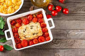 Preparation of ingredients for feta pasta. Trending Feta bake pasta recipe made of cherry tomatoes, feta cheese, garlic and herbs. Top view, copy space.