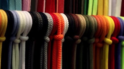 Wall Mural - different colors of laces or rope on the shelves of a clothing factory