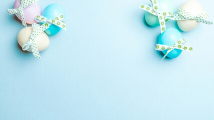 Wall Mural - Easter flat. Colorful egg with tape ribbon on pastel blue background in Happy Easter decoration. Spring holiday top view concept.